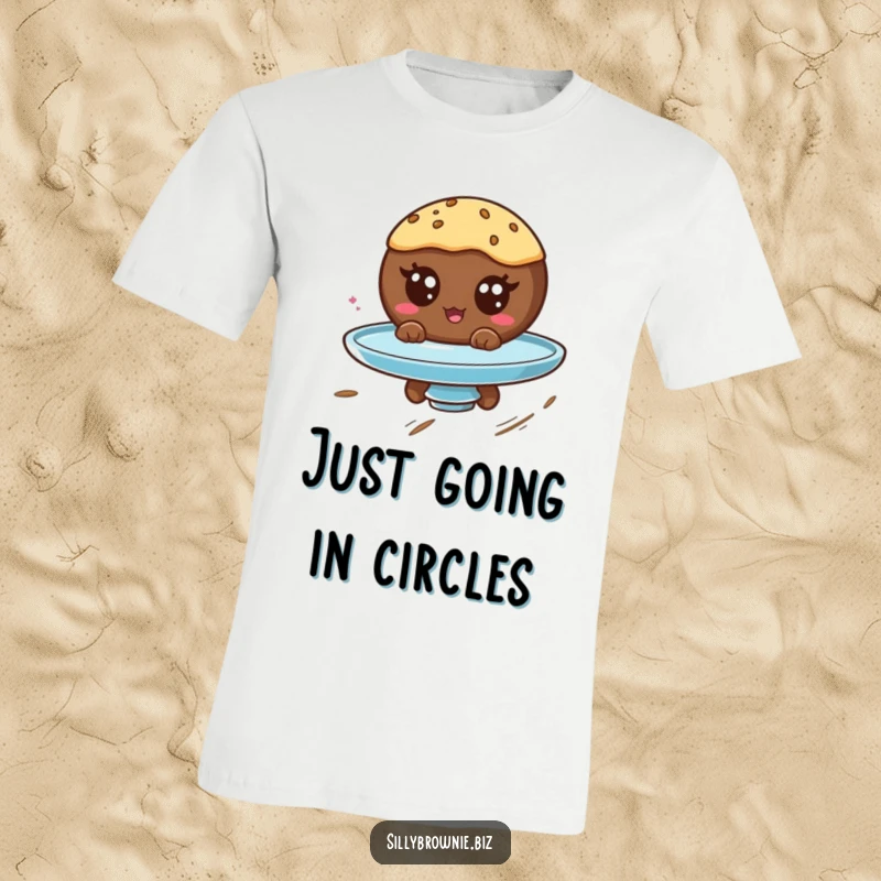 Funny t-shirt showing a round brownie character with googly eyes spinning wildly on a plate, conveying pure, dizzy amusement.